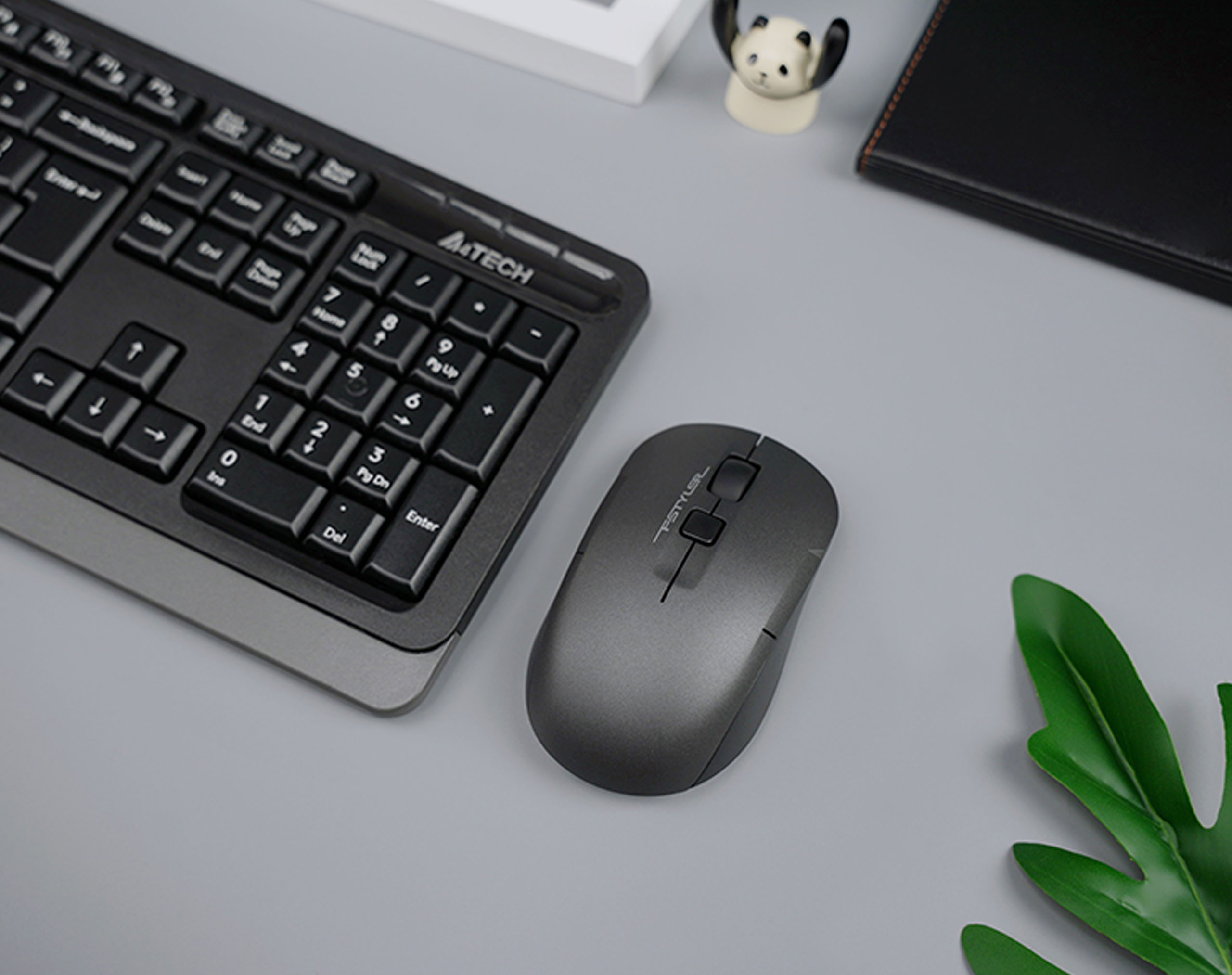 FG16CS Air2 black mouse beside a keyboard on a gray desk