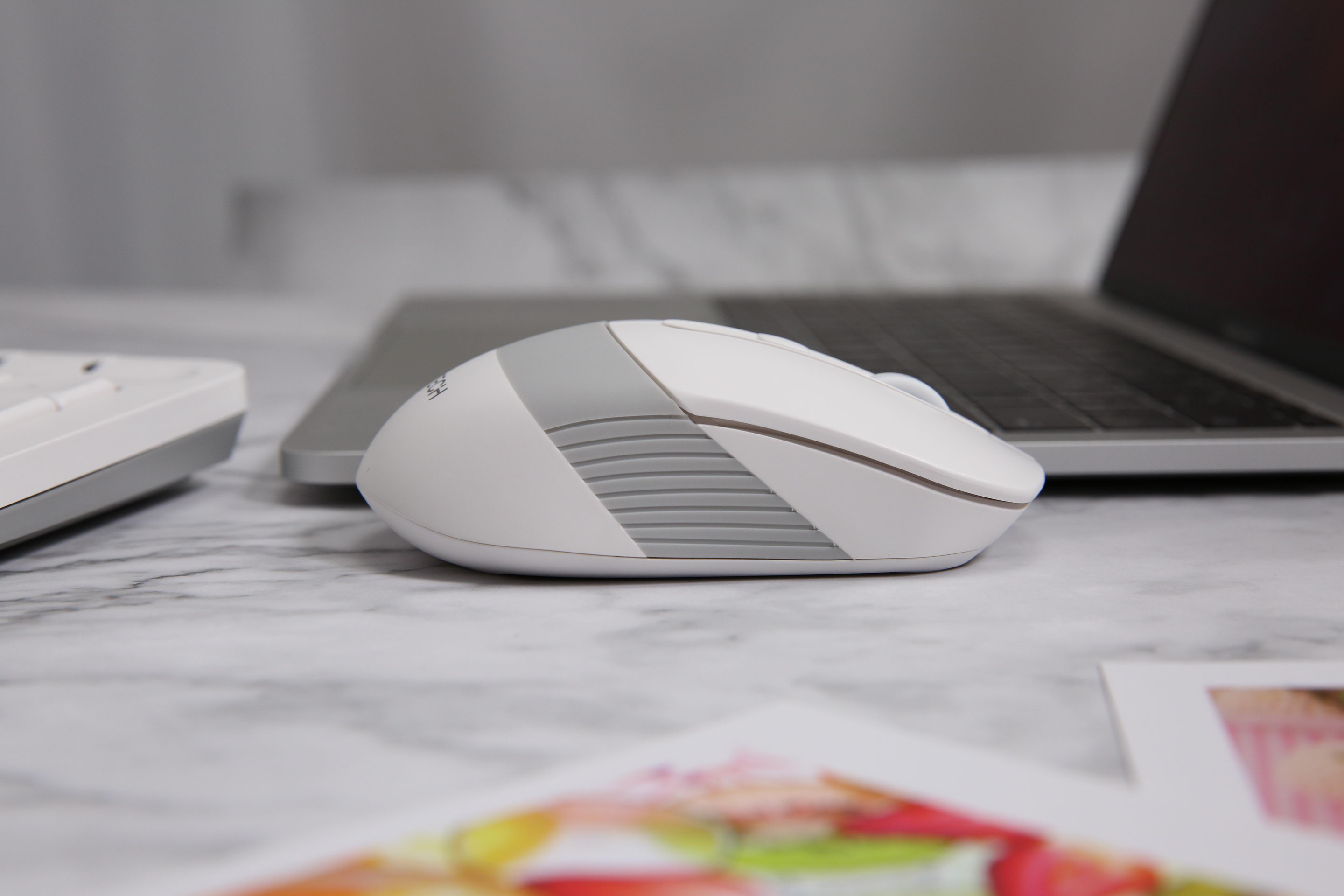 FG10S white mouse in profile beside a laptop