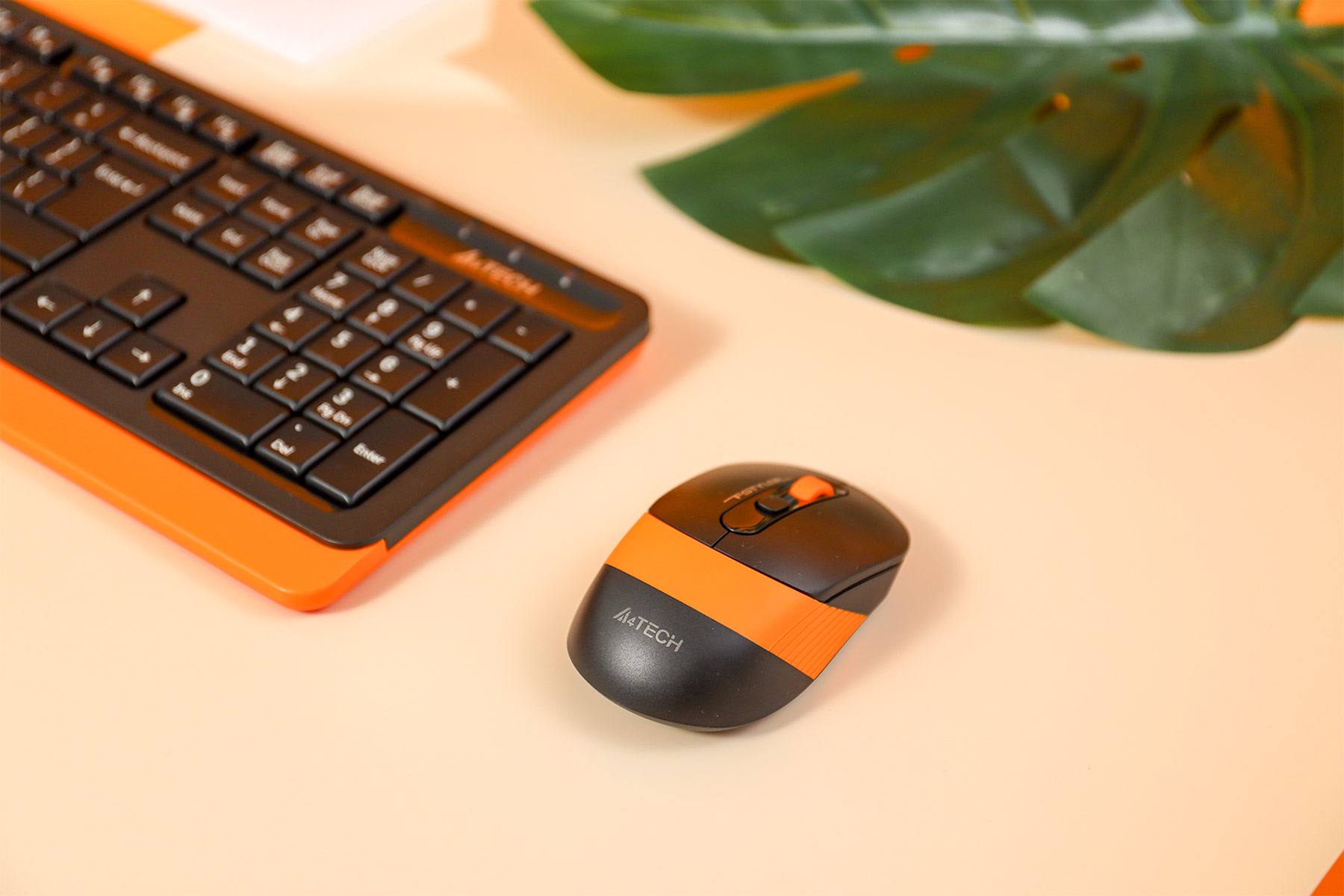 FG10S black and orange mouse beside a matching keyboard