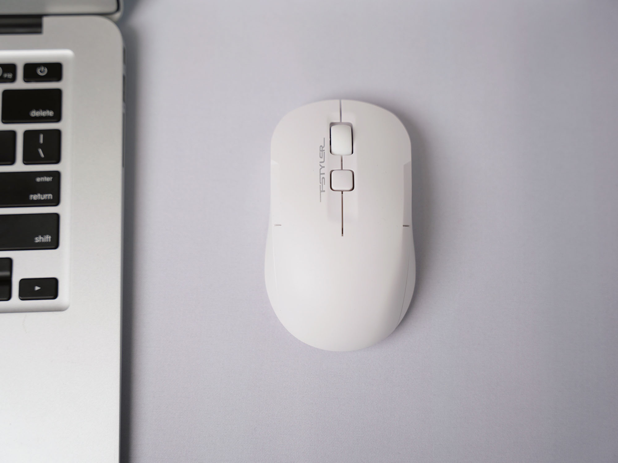 FG16CS Air2 white mouse viewed from above beside a laptop